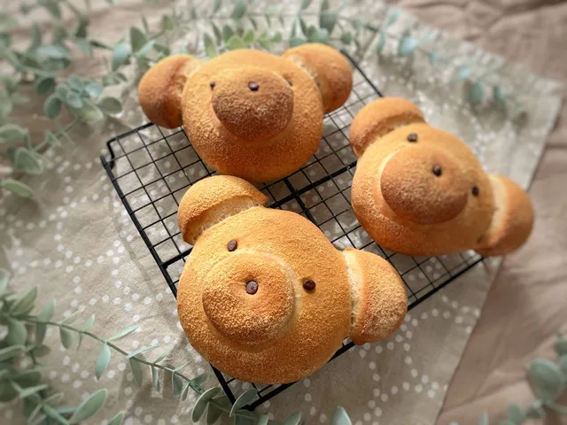 ココアパウダーをまとった、くまの形の焼きたてパン3つ